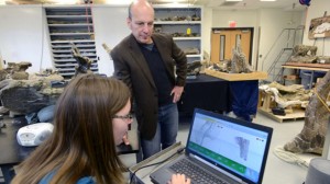 Paleontologist Dr. Kenneth Lacovara reviews digital 3D scans of Dreadnaughtus with student Emma Fowler.